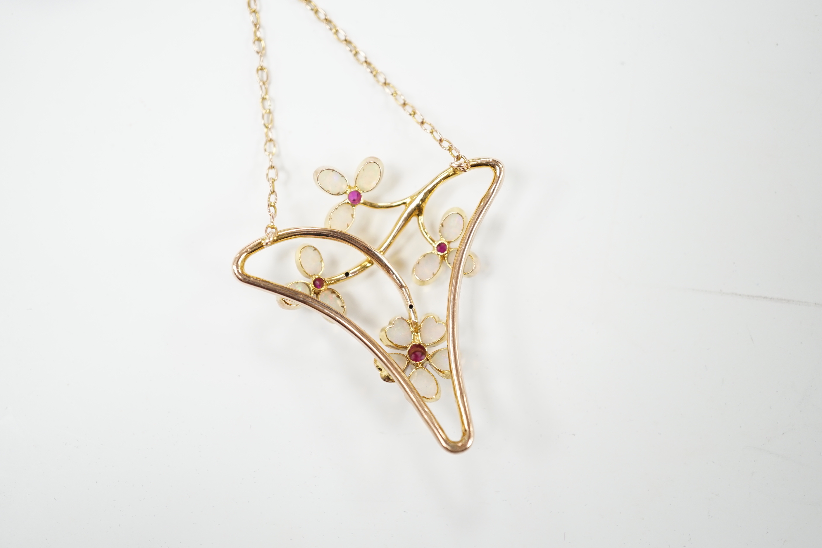 A yellow metal ruby and white opal set Art Nouveau style necklace, in Carrington & Co. box, 4cm